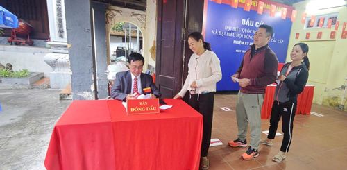 Cử tri Từ Liêm phấn khởi xếp hàng nhận giấy xác nhận đã bỏ phiếu. Ảnh: PV