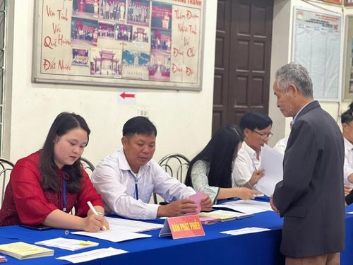 Thành viên tổ bầu cử hướng dẫn cử tri thực hiện các bước bỏ phiếu.