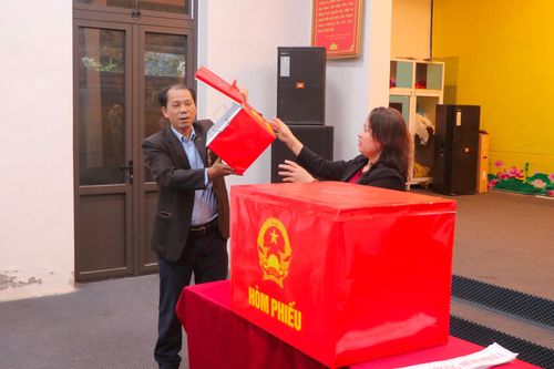 Thành viên tổ bầu cử thực hiện kiểm tra hòm phiếu chính và hòm phiếu phụ. Ảnh: Duy Linh