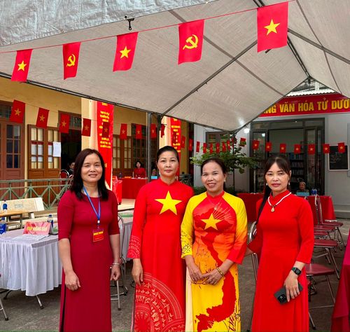 Thành viên tổ phục vụ trong tà áo dài góp phần tạo nên không khí trang trọng, phấn khởi trong ngày hội toàn dân đi bầu cử tại xã Chương Dương.