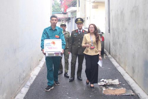 Tổ bầu cử khu vực bỏ phiếu số 15 mang hòm phiếu phụ đi qua từng ngõ xóm, bảo đảm quyền bầu cử cho các cử tri không thể đến điểm bỏ phiếu. Ảnh: Mai Khôi