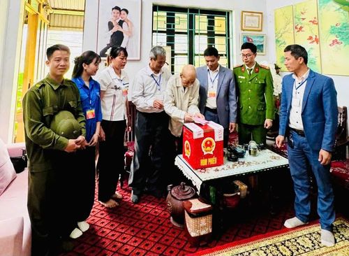 Cụ Trịnh Đình Rẫn trân trọng bỏ lá vào hòm phiếu. Ảnh: PV