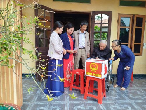 Các tổ bầu cử chủ động mang hòm phiếu phụ đến tận nhà các cử tri là người cao tuổi, người khuyết tật, cử tri ốm đau không thể trực tiếp đến điểm bỏ phiếu. Ảnh: Thu Nghĩa