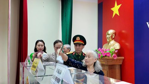 Cử tri Lê Thị Thương (đi cuối) tiến hành bỏ phiếu bầu cử. Ảnh: Công Sơn