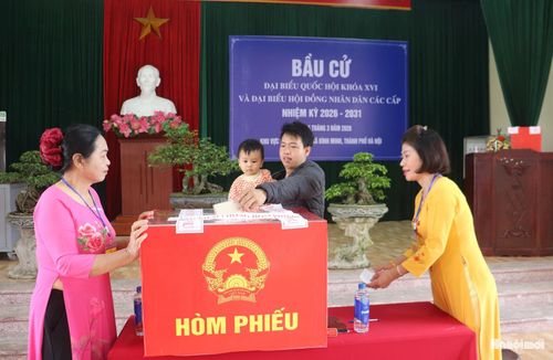 Nhiều cử tri bế theo con đi bầu cử tại khu vực bỏ phiếu số 38, xã Bình Minh. Ảnh Đ.Đ
