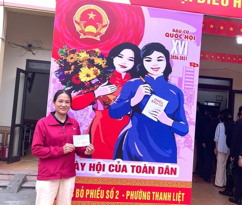 Cử tri Bùi Thị Mai vui mừng cầm thẻ cử tri đã được đóng dấu “Đã bỏ phiếu”. Ảnh: Đào Tuyết.