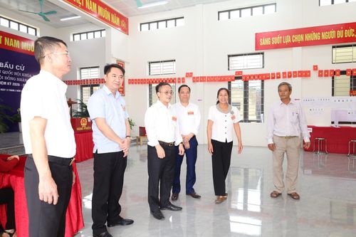 Bí thư Đảng ủy xã Phúc Sơn Phan Văn Sự cùng các thành viên Ban Chỉ đạo bầu cử xã kiểm tra tình hình tại các khu vực bầu cử chiều 15-3. Ảnh: Kim Nhuệ
