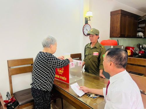 Cử tri cao tuổi xã Ô Diên bỏ phiếu tại nhà với sự hỗ trợ của Tổ bầu cử. Ảnh: Nguyệt Quế