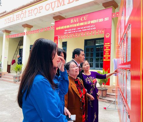 Cử tri xã Ô Diên nghiên cứu tiểu sử các ứng cử viên trước khi vào bầu cử. Ảnh: Ánh Bình
