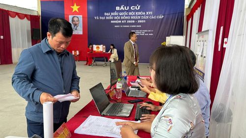 Cán bộ tổ bầu cử trên địa bàn xã Thường Tín hướng dẫn cử tri thủ tục bầu cử. Ảnh: Công Tâm