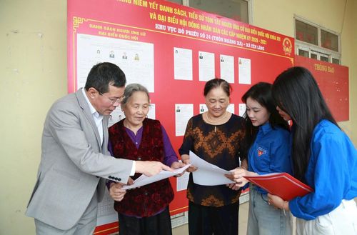 Cán bộ, thanh niên tình nguyện xã Yên Lãng tuyên truyền, hướng dẫn người dân về Luật Bầu cử và các quy định khi tham gia bầu cử. Ảnh: Phạm Hùng