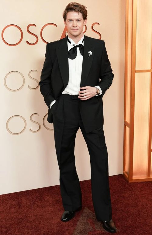  Joe Alwyn mặc bộ suit Valentino đen đặt may riêng. Bạn trai cũ của Taylor Swift tạo điểm nhấn phá cách với chiếc nơ cổ buộc lỏng. Ảnh: People. 