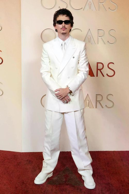 Timotheé Chalamet gây chú ý với bộ suit trắng toàn tập của Givenchy. Anh kết hợp trang phục với kính râm đen và giày cùng tông, tạo phong cách thời trang hiện đại và phá cách. Lựa chọn táo bạo giúp nam diễn viên trở thành một trong những gương mặt nổi bật trên thảm đỏ.