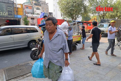 Ông Đào Văn Chí, một tài xế xe ôm truyền thống, thường xuyên đến phụ giúp chuyển cơm tại điểm phát.