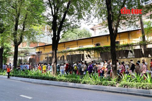 Khoảng 9 giờ 30 phút sáng trước cổng Lý Tự Trọng của Bệnh viện Nhi Đồng 2, dòng người bắt đầu xếp hàng dài, chờ đến lượt nhận cơm miễn phí.