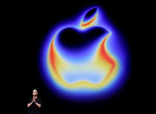Logo Apple rực rỡ sắc màu và CEO của hãng Tim Cook. (Nguồn: Getty Images)