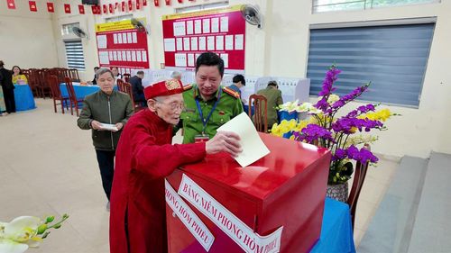 Khoảnh khắc cụ Pha trực tiếp bỏ phiếu tại khu vực bầu cử là một hình ảnh đẹp mang ý nghĩa biểu trưng về "ngọn đuốc dẫn đường" của thế hệ đi trước dành cho thế hệ trẻ hôm nay và mai sau. Ảnh: Hồng Quý