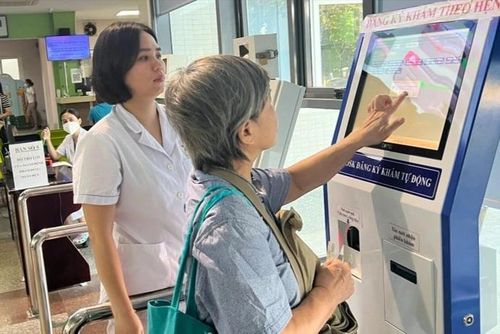 Người dân làm thủ tục khám với các kiốt điện tử, rút ngắn thời gian chờ đợi khám tại Bệnh viện Đa khoa Đức Giang (Hà Nội).