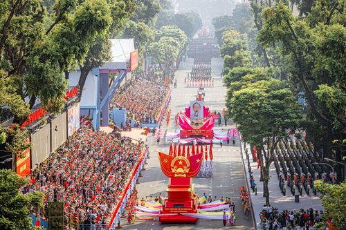 Tác phẩm: Xe mô hình rước Quốc huy và xe chở chân dung Chủ tịch Hồ Chí Minh dẫn đầu đoàn diễu hành tiến qua lễ đài tại Lễ kỷ niệm 50 năm Ngày Giải phóng miền Nam, thống nhất đất nước (30/4/1975 - 30/4/2025). Ảnh: Lê Văn Minh/TTXVN