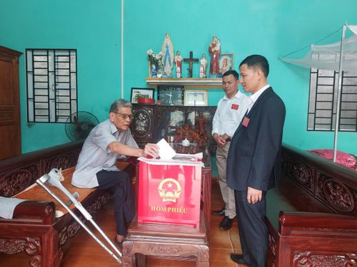 Thương binh Dương Quang Thọn do không thể đi lại đã được bỏ phiếu tại nhà với hòm phiếu di động của khu vực bỏ phiếu số 6, xã Kẻ Sặt. Ảnh: Trần Thu
