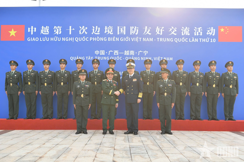 Bộ trưởng Bộ Quốc phòng hai nước chụp ảnh lưu niệm cùng các cán bộ, chiến sĩ Đại đội Biên phòng Đông Hưng.