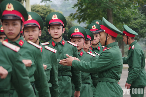 Đồng chí Tiểu đội trưởng trực tiếp uốn nắn động tác cho chiến sĩ mới trong giờ huấn luyện.