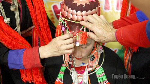 Ngoài trang phục áo dài được thêu hoa văn cầu kỳ, về nhà trai, cô dâu còn có thêm những chiếc khăn thêu để buộc áo, chiếc mũ đội đầu thêu hoa văn có rua bốn bên và chiếc khăn che mặt được thêu bằng những sợi chỉ màu sặc sỡ.