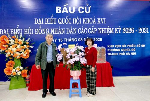 Ông Nguyễn Ngọc Quang đại diện tổ bầu cử nhận hoa của nhân dân tặng chúc mừng ngày bầu cử và động viên tinh thần các thành viên trong tổ. Ảnh: MT