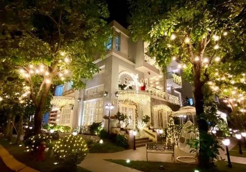 Bao quanh biệt thự là khoảng sân xanh mướt, được phủ kín bởi nhiều loại cây cảnh. Ảnh: FBNV