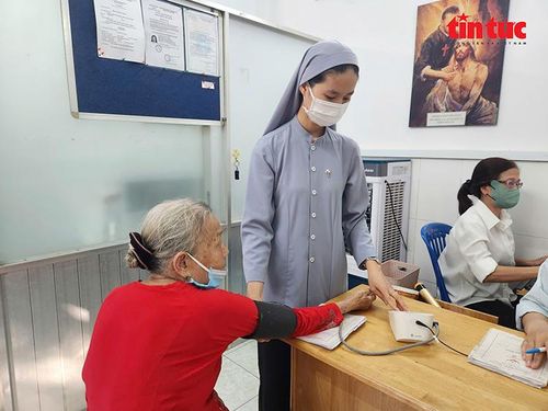 Nữ tu sĩ kiểm tra huyết áp cho bệnh nhân.