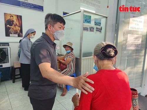 Linh mục Đaminh Đinh Trần Thanh Tú hỗ trợ bệnh nhân khi đến khám bệnh.