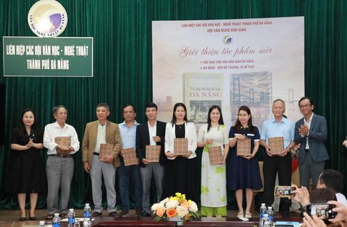 Lãnh đạo Liên hiệp các Hội Văn học - Nghệ thuật thành phố Đà Nẵng (bên phải) tặng 2 cuốn sách mới cho đại diện các đơn vị, trường học trên địa bàn thành phố. Ảnh: ĐẮC MẠNH