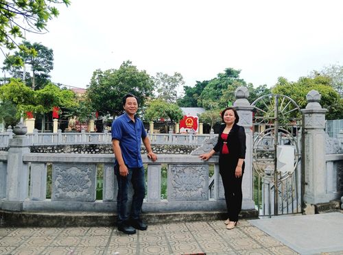 Bí thư Chi bộ thôn Vĩnh Trung Nguyễn Ngọc Diệp và Trưởng thôn Nguyễn Thị Hường bên giếng cổ đã được kè đá, tôn tạo. Ảnh: Hoàng Quyết