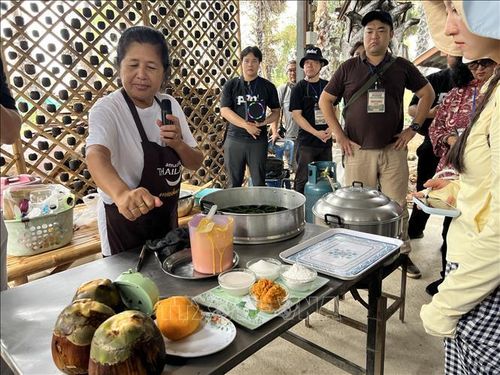 Người dân địa phương giới thiệu cách làm món bánh tráng miệng làm từ bột nếp và dịch quả thốt nốt. Ảnh: Đỗ Sinh/PV TTXVN tại Thái Lan