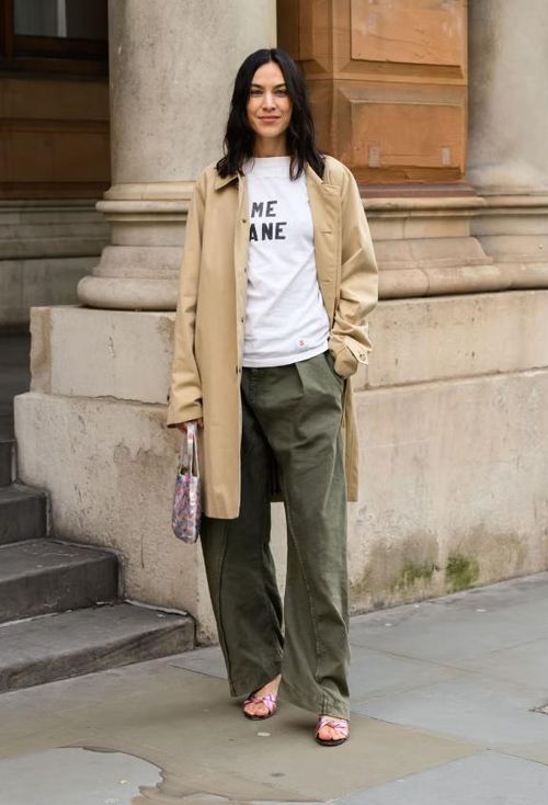 Một chiếc trench khaki kết hợp với các món đồ basic tinh tế là combo an toàn, nhưng để tạo nét phá cách, hãy thử áo thun graphic + quần utility tone khác với đen. Giày metallic hồng Barbie và túi sequin cùng tone sẽ mang đến điểm nhấn tinh tế, khiến tổng thể nổi bật mà không quá phô trương. Ảnh: Getty Images