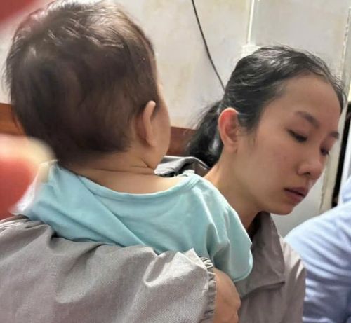 Chị Lê Thị Thùy Hân - vợ của Đại úy Nguyễn Xuân Hải tay bồng con thơ, gương mặt thất thần khi nghe tin chồng đã hy sinh trong khi thi hành công vụ.