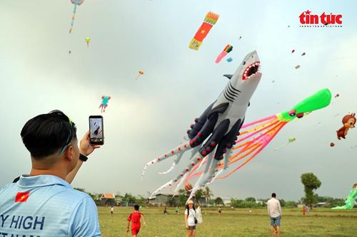 Nghệ nhân Nguyễn Đăng Thịnh, chủ nhiệm Câu lạc bộ Sharktopus Kite Team dùng điện thoại ghi lại hình ảnh con diều bạch tuộc sau khi được thả lên bầu trời.