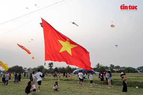 Cờ Tổ quốc được những con diều khổng lồ kéo lên bầu trời.