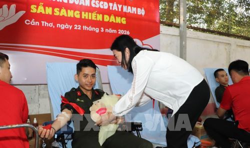 Đại biểu tặng quà đến chiến sĩ tham gia hiến máu. Ảnh: Hồng Thái - TTXVN