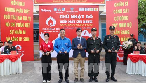 Đại diện các đơn vị có thành tích trong công tác vận động hiến máu tình nguyện nhận kỷ niệm chương. Ảnh: Hồng Thái - TTXVN