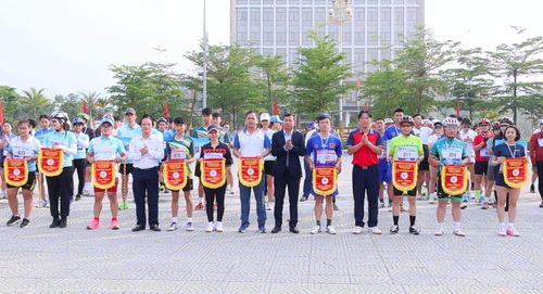 Ban Tổ chức trao cờ lưu niệm cho các đoàn tham gia tranh tài chạy việt dã và đua xe đạp. Ảnh: Minh Đức