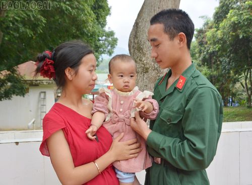 Chiến sĩ Thào Vênh ân cần dỗ dành con gái nhỏ.