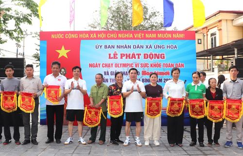 Lãnh đạo xã Ứng Hòa trao Cờ lưu niệm cho các đoàn về dự lễ phát động. Ảnh: Hoàng Sơn