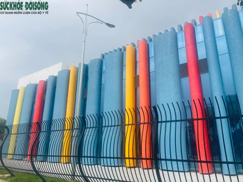 Tông màu xanh lam được sử dụng làm nền chủ đạo, xen kẽ là những dải màu đỏ, vàng, cam chạy dọc thân nhà, tạo nên hiệu ứng thị giác mạnh và dễ nhận diện từ xa.