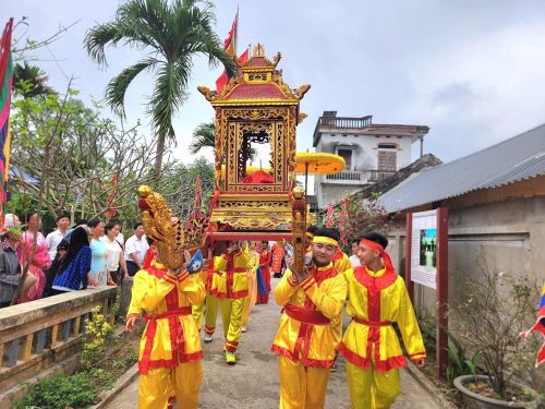Đoàn rước kiệu di chuyển qua các tuyến đường làng trong không khí rộn ràng, thu hút đông đảo người dân theo dõi và tham gia