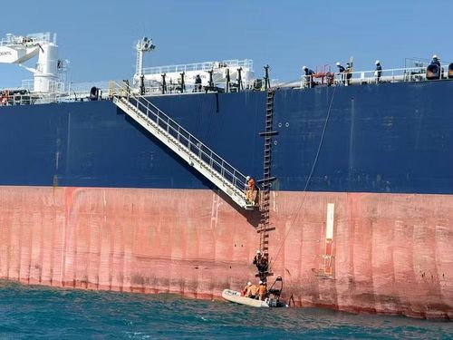 Nhân viên cứu nạn của tàu SAR 413 đang tiếp cận tàu có thủy thủ bị bệnh để đưa người này về bờ.