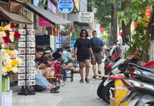 Đường Trần Phú, phường Hải Châu, đoạn đối diện nhà thờ Con Gà, quán cà phê kê bàn ghế ra vỉa hè. Người đi bộ chỉ còn lối nhỏ để di chuyển