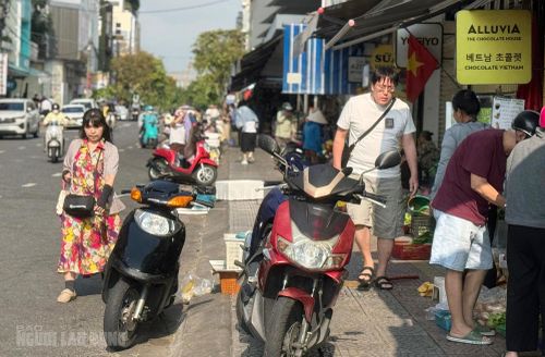 Du khách chen chân với xe máy cùng quầy hàng tràn ra vỉa hè trên đường Nguyễn Thái Học