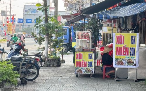 Bà Phạm Thị Minh Vy kê vật dụng vào bên trong, chừa lối cho người đi bộ và cho biết chỉ bán ở khoảng đầu giờ sáng