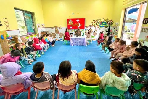 Học sinh mầm non lắng nghe cựu chiến binh kể chuyện về những năm tháng chiến tranh. (Ảnh: Tô Dung)